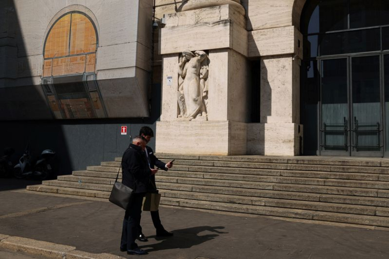 Des personnes se tiennent à côté de la Bourse de Milan