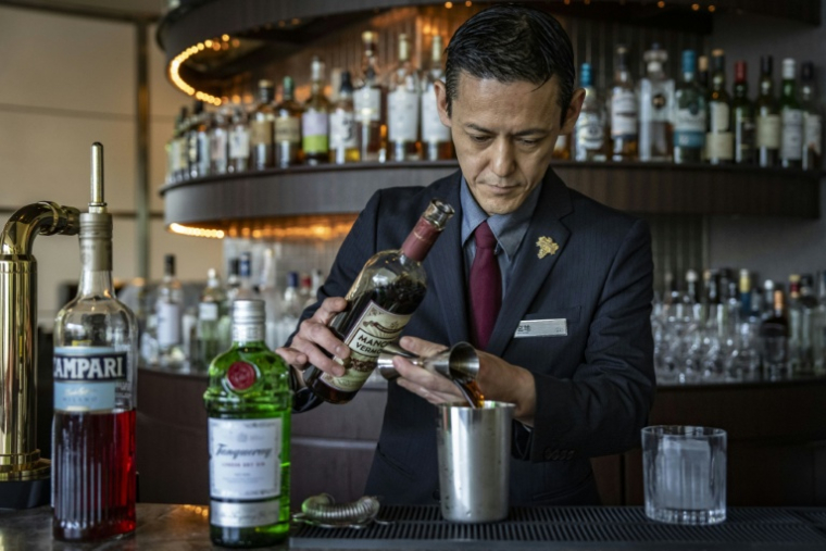 Le barman Shingo Miyachi prépre un cocktail negroni au bar de l'hôtel Hilton de Narita, au Japon, le 19 juin 2026 ( AFP / Yuichi YAMAZAKI )