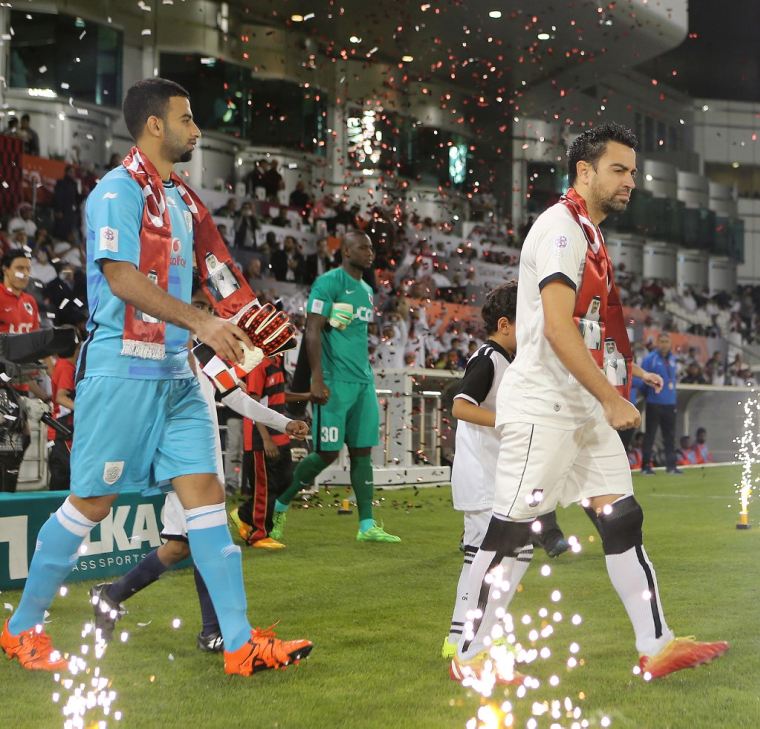 Xavi Hernandez et le gardien de but Saad Abdulla Al-Sheeb le 10 décembre 2015 à Doha. ( AFP / KARIM JAAFAR )