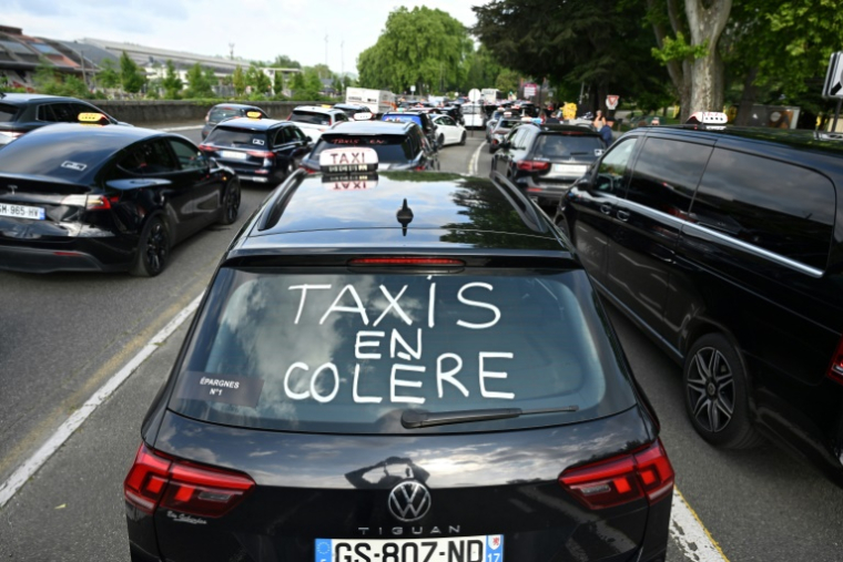 Un slogan "Taxis en colère" est inscrit sur une voiture alors que des chauffeurs de taxi participent à une opération de blocage à Pau, le 19 mai 2025 ( AFP / Gaizka IROZ )