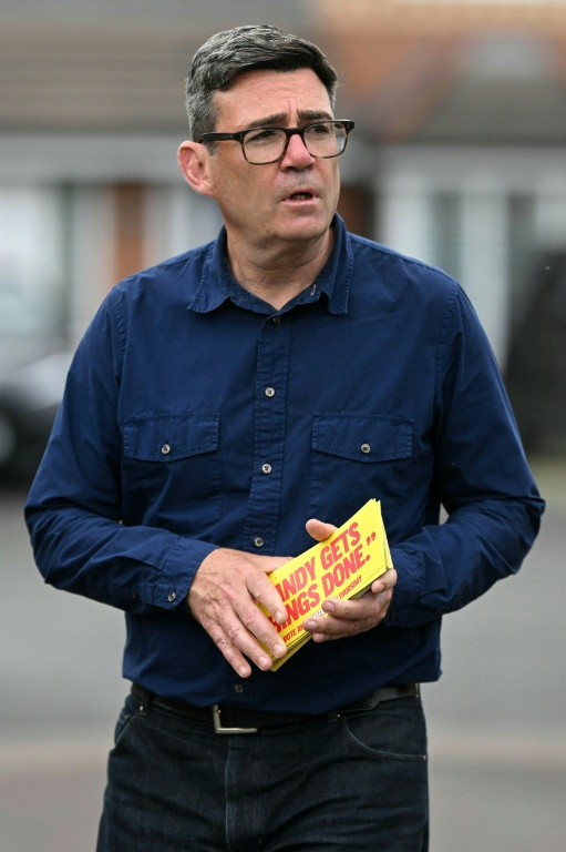 Andy Burnham, maire du Grand Manchester et candidat du Parti travailliste à l'élection partielle de Makerfield, dans le nord-ouest de l'Angleterre, tracte à Hindley le 16 juin 2026 ( AFP / Oli SCARFF )