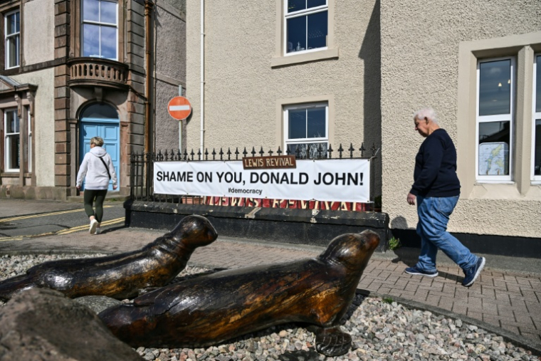 Une banderole anti-Trump devant un magasin à Stornoway, sur l'île de Lewis, en Ecosse, le 29 avril 2025 ( AFP / Andy Buchanan )