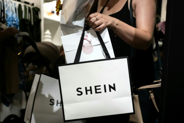 Une cliente à la sortie d'un magasin éphémère de la marque chinoise de fast fashion Shein à Dijon, le 26 juin 2025  ( AFP / ARNAUD FINISTRE )