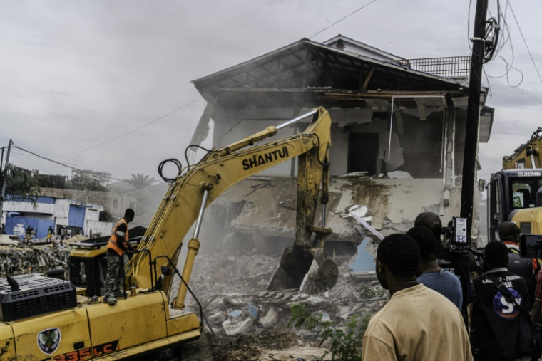 Un engin de chantier démolit des maisons à Kinshasa,, après que les autorités de la RDC ont décidé de démolir tous les bâtiments non autorisés dans les zones inondables, le 8 mai 2025 en RDC ( AFP / Glody MURHABAZI )