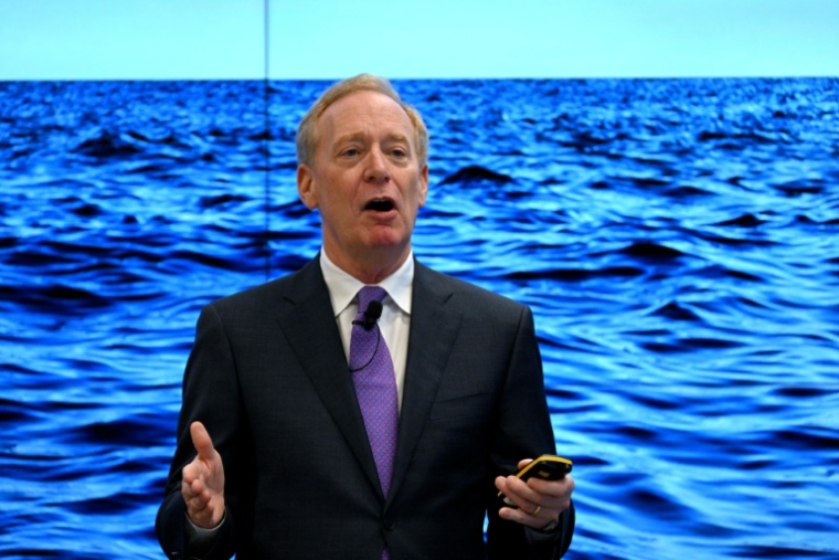 Le président de Microsoft Brad Smith, devant un écran géant, à Bruxelles le 30 avril 2025 ( AFP / Nicolas TUCAT )