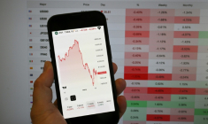 Les cours de la Bourse sur un téléphone portable à Bruxelles le 12 mars 2026. ( AFP / Nicolas TUCAT )