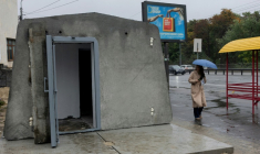 Une femme passe à côté du premier abri antiaérien installé à Kiev, le 16 octobre 2026 ( AFP / Tetiana DZHAFAROVA )
