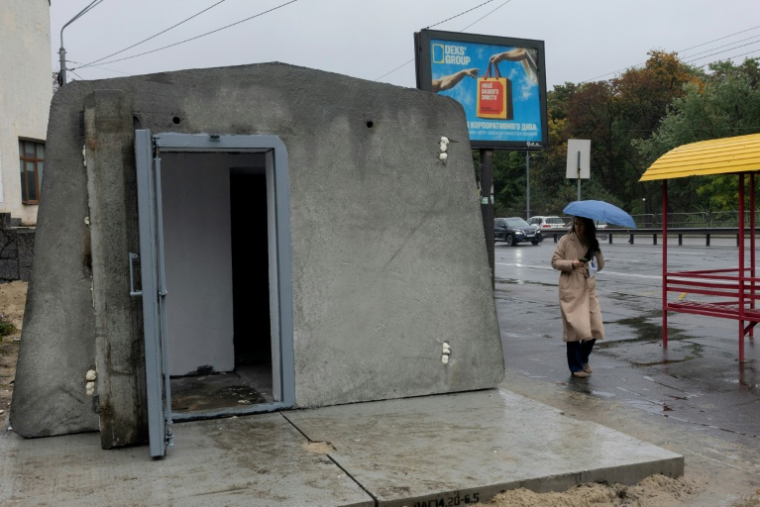 Une femme passe à côté du premier abri antiaérien installé à Kiev, le 16 octobre 2026 ( AFP / Tetiana DZHAFAROVA )