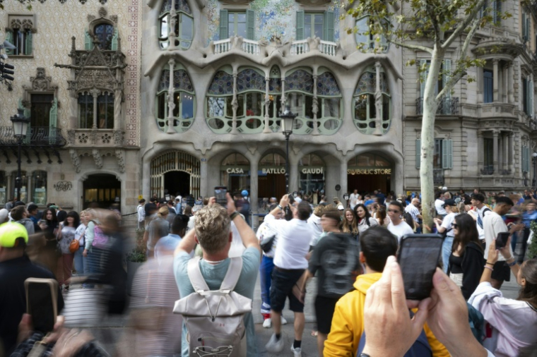 Des touristes devant la Casa Batllo, une création d'Antoni Gaudi, à Barcelone, le 11 octobre 2024, en Espagne ( AFP / Josep LAGO )