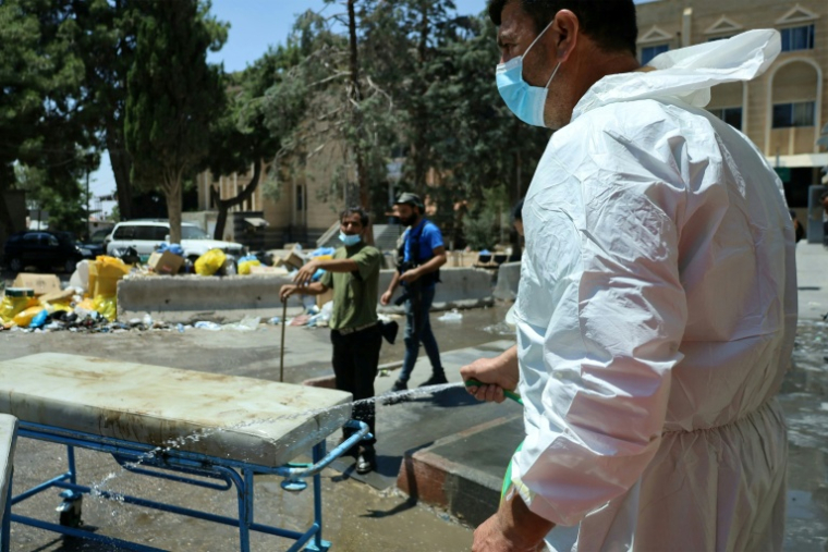 Du personnel médical nettoie des équipements devant l'hôpital de Soueida, dans le sud de la Syrie, le 20 juillet 2025 ( AFP / Shadi AL-DUBAISI )