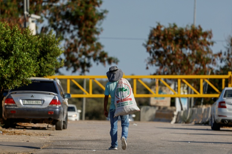 Un Palestinien porte un sac rempli d'olives dans le the village de Rantes près de Ramallah, en Cisjordanie occupée, le 6 octobre 2026 ( AFP / Zain JAAFAR )
