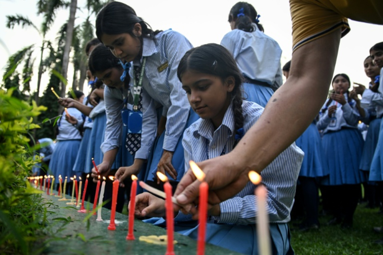 Des personnes en deuil et des élèves allument des bougies pour présenter leurs condoléances après la mort de l'alpiniste Nirmal Purja et de ses compagnons, emportés par une avalanche au Pakistan ; la scène se déroule à l'école Small Heaven de Chitwan, le 2 août 2026.  ( AFP / Prakash MATHEMA )