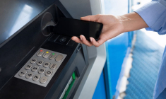 (Crédits photo : Adobe Stock - Femme réalisant un retrait d'espèces avec son smartphone au distributeur automatique de billets de sa banque)