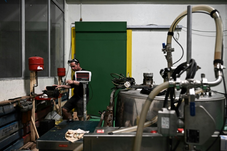 Un membre de "Roule ma frite", une association spécialisée dans la récupération et le recyclage des huiles de friture usagées en circuit court, lors du recyclage d'huile de friture usagée à Bourcefranc-le-Chapus, le 10 mai 2022 en Charente-Maritime ( AFP / Philippe LOPEZ )