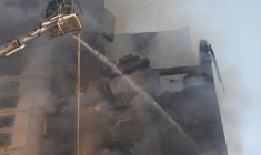 Pompiers sur le site d'un immeuble d'habitation touché par une frappe aérienne russe, à Kharkiv