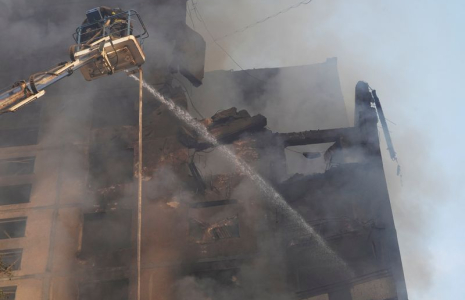 Pompiers sur le site d'un immeuble d'habitation touché par une frappe aérienne russe, à Kharkiv