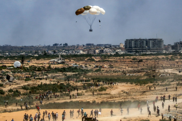 Des Palestiniens se précipitent pour récupérer de l'aide humanitaire parachutée au-dessus de Nousseirat, dans le centre de la bande de Gaza, le 5 août 2025 ( AFP / Eyad BABA )