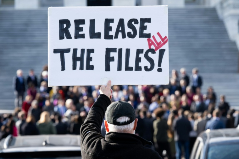 Un manifestant tient une pancarte "Publiez tous les dossiers", demandant la publication des documents liés à l'affaire Epstein, devant le Capitole de Washington, siège du Congrès américain, le 12 novembre 2025 ( AFP / SAUL LOEB )
