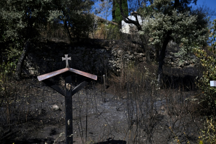 Une croix dans un terrain ravagé par les flammes près du sanctuaire Notre-Dame de Bonne-Grâce à Cotignac, dans le Var, le 24 juillet 2026 ( AFP / Frederic DIDES )