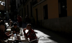 Des personnes déjeunent à des tables en plein air dans un restaurant du centre de Madrid