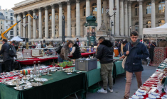 Une personne marche dans un marché devant l'ancienne Bourse de Paris