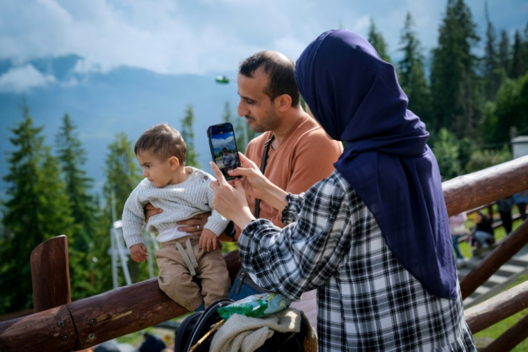 Des touristes prennent des photos de la vue sur les montagnes des Tatras, en Pologne, le 4 août 2025 ( AFP / BARTOSZ SIEDLIK )