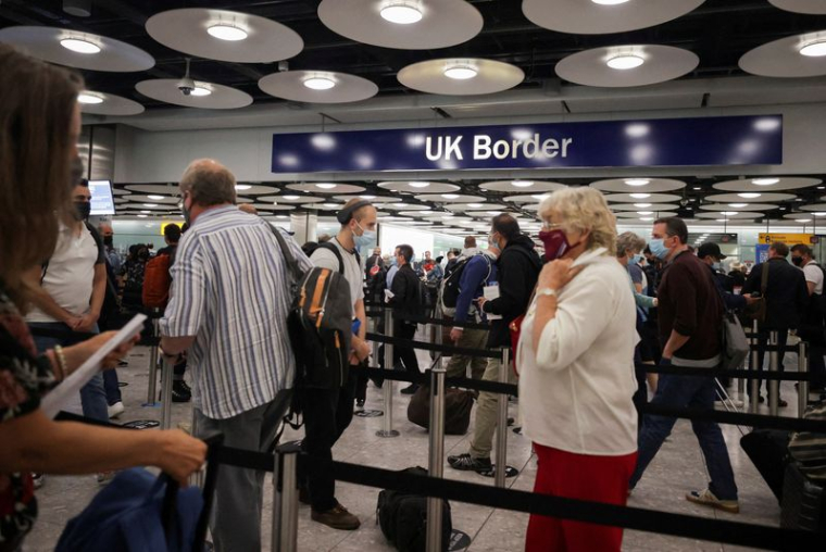 Les passagers font la queue au contrôle des frontières britanniques à l'aéroport d'Heathrow à Londres