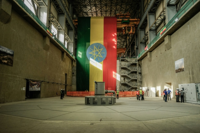 Des ouvriers sont vus sur le site du Grand Barrage de la Renaissance Éthiopienne (GERD) à Guba, en Éthiopie, le 19 février 2022. Le Grand Barrage de la Renaissance Éthiopienne (GERD), le plus grand projet hydroélectrique d'Afrique, promet un important coup de pouce économique et une "révolution énergétique" pour le pays, selon les analystes, mais constitue également une source de friction géopolitique.S'élevant à 145 mètres de haut et s'étendant sur près de deux kilomètres à travers le Nil Bleu, près de la frontière soudanaise, cette méga-structure de 4 milliards de dollars est conçue pour contenir 74 milliards de mètres cubes d'eau et générer 5 000 mégawatts d'électricité -- soit plus du double de la capacité actuelle de l'Éthiopie. ( AFP / Amanuel SILESHI )