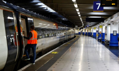 Un employé ferroviaire à côté d'un train à la gare d'Euston à Londres, en Grande-Bretagne