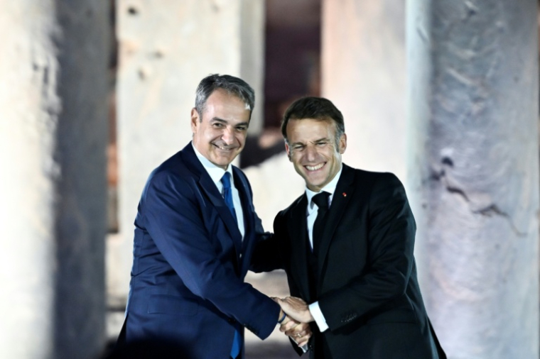 Le Premier ministre grec Kyriakos Mitsotakis (g) et le président français Emmanuel Macron à l'issue d'un événement à l'Agora romaine d'Athènes, le 24 avril 2026 en Grèce ( AFP / Aris MESSINIS )