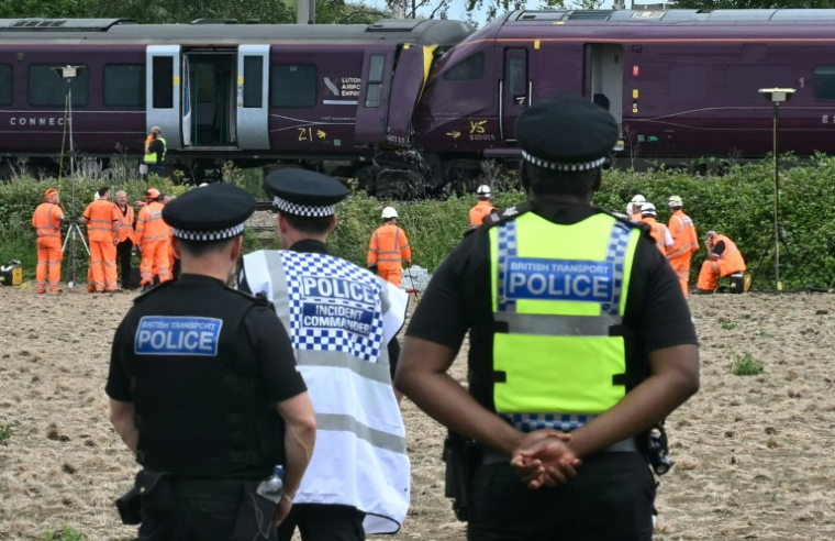 Des agents de la police des transports britannique et des enquêteurs sur le site d'une collision entre deux trains de la compagnie East Midlands Railway (EMR) survenue la veille, le 20 juin 2026 au sud de Bedford, dans le centre de l'Angleterre  ( AFP / JUSTIN TALLIS )
