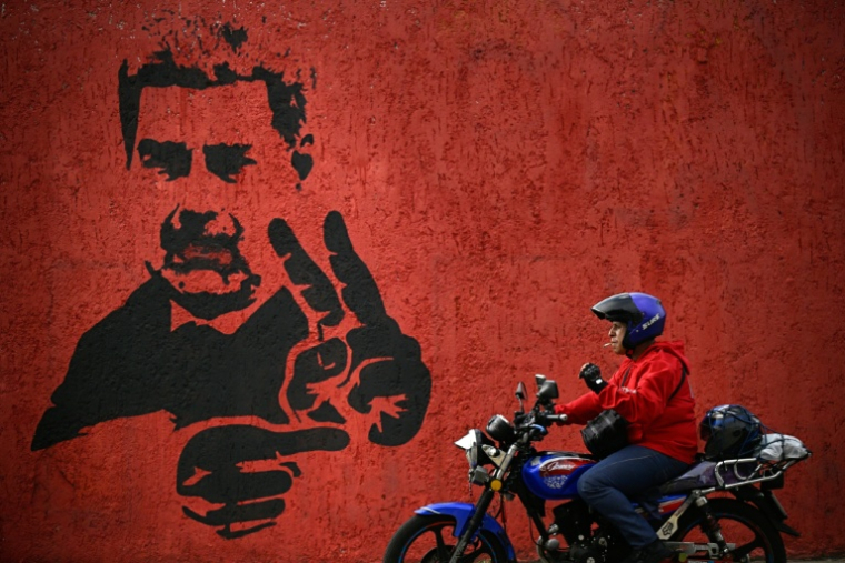 Un homme passe près d'une fresque représentant Nicolas Maduro, le 14 mai 2026 à Caracas ( AFP / Federico PARRA )