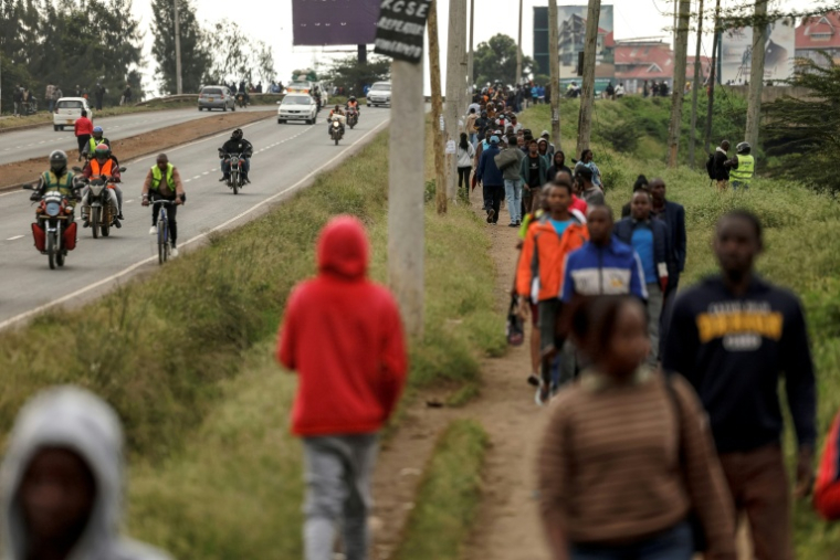 Des Kényans marchent le long d'une voie rapide de Nairobi, le 18 mai 2026, jour de grève des transports publics et de protestations contre la hausse des prix des carburants au Kenya ( AFP / SIMON MAINA )