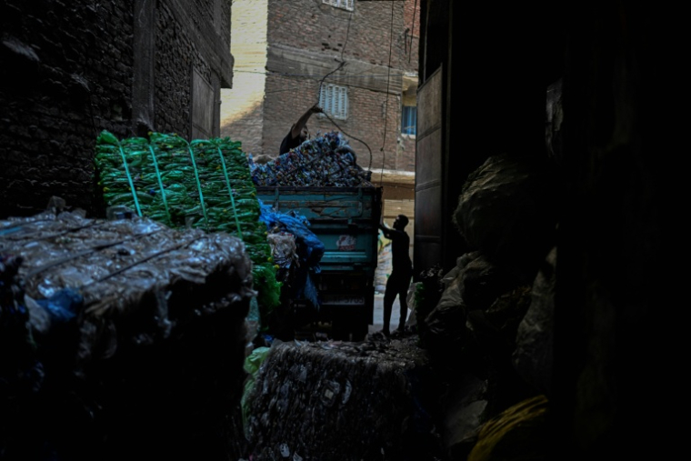 Des travailleurs égyptiens chargent des ballots de plastique à recycler dans la "ville des déchets"n dans le quartier du Caire de Manshiyet Nasser, le 6 juillet 2026. ( AFP / Khaled DESOUKI )