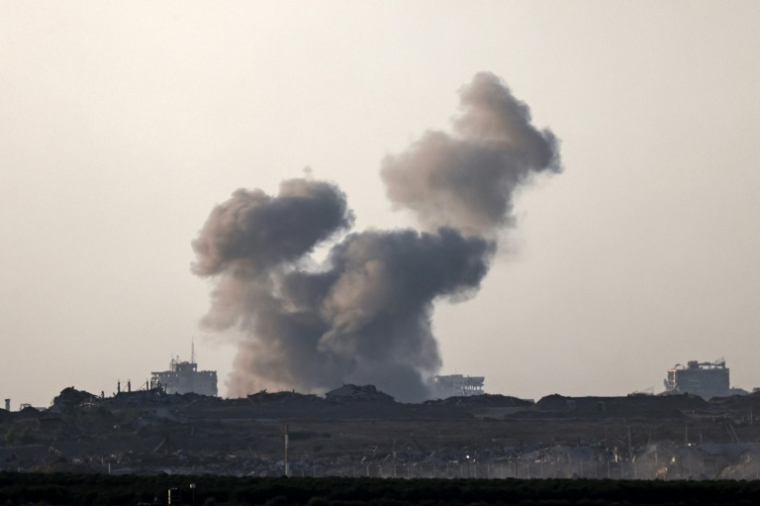 Photo prise depuis une position à la frontière entre Israël et la bande de Gaza montrant de la fumée au-dessus d'un secteur du territoire palestinien et des véhicules militaires après une frappe israélienne, le 20 août 2025 ( AFP / AHMAD GHARABLI )