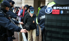 Des visiteurs passent devant des policiers alors qu'ils entrent dans le tribunal de première instance de West Kowloon à Hong Kong, le 22 janvier 2026 ( AFP / Peter PARKS )