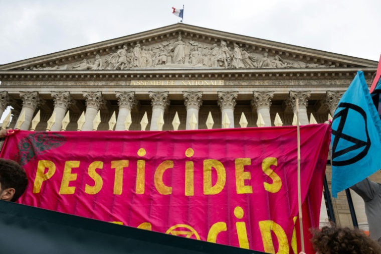 Une banderole "Pesticides" devant l'Assemblée nationale, lors d'une manifestation à Paris, le 27 mai 2025 ( AFP / Leo VIGNAL )