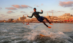 Un jeune Palestinien surfe au large d'une une plage de la ville de Gaza, le 21 juin 2026  ( AFP / Omar AL-QATTAA )