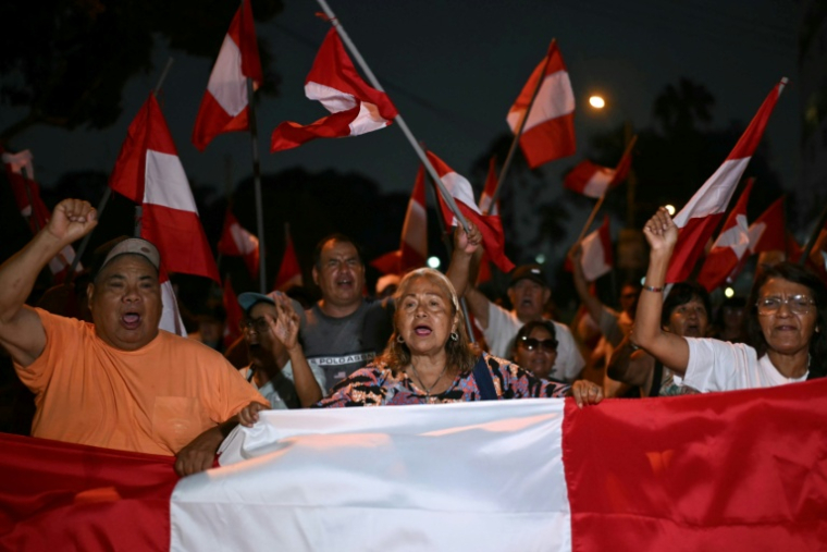 Des manifestants brandissent des drapeaux péruviens lors d'une manifestation devant le siège du Jury national des élections (JNE) à Lima, le 14 avril 2026 ( AFP / ERNESTO BENAVIDES )