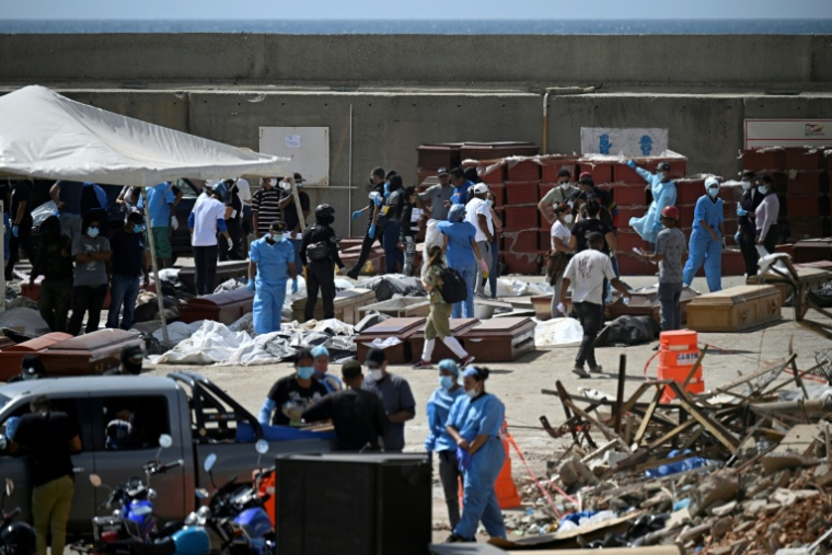 Des experts médicolégaux procèdent à l'identification de corps étendus au sol dans une morgue de fortune située dans le port de La Guaira, au Venezuela, le 29 juin 2026 ( AFP / Federico PARRA )