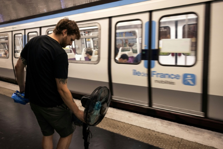 Une personne prend le métro avec un ventilateur, à Paris, le 10 juillet 2026 ( AFP / Behrouz MEHRI )