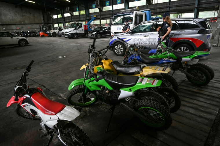 Des policiers se tiennent près de motos saisies après des rodéos urbains, le 13 juillet 2021 à Lyon  ( AFP / PHILIPPE DESMAZES )