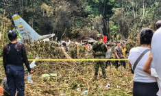 Des civils et des militaires se tiennent près des débris d'un Hercules de l'armée de l'air colombienne qui s'est écrasé au décollage à Puerto Leguizamo, en Colombie, le 23 mars 2026 ( AFP / daniel ortiz )