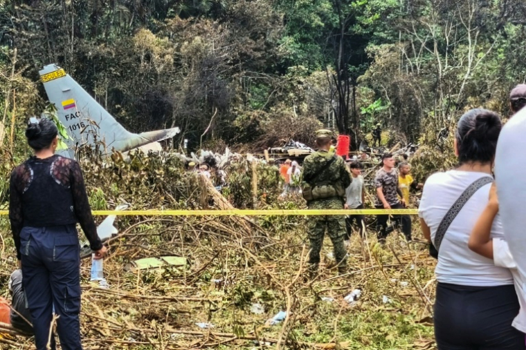 Des civils et des militaires se tiennent près des débris d'un Hercules de l'armée de l'air colombienne qui s'est écrasé au décollage à Puerto Leguizamo, en Colombie, le 23 mars 2026 ( AFP / daniel ortiz )