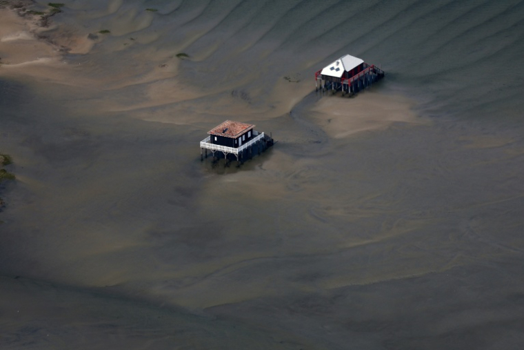 Cette photographie aérienne montre une vue des bungalows sur pilotis dits « Cabanes Tchanquées », près de l’Île aux Oiseaux, dans le bassin d’Arcachon, dans le sud-ouest de la France, le 24 juillet 2026 ( AFP / ROMAIN PERROCHEAU )