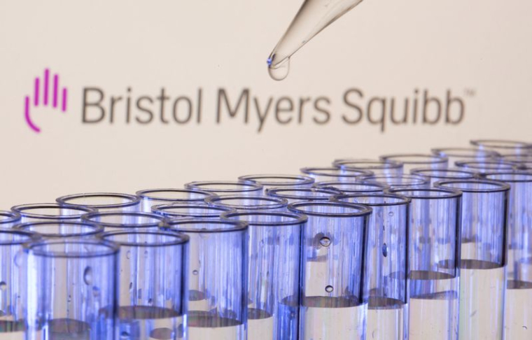 Des tubes à essai devant le logo de Bristol Myers Squibb.