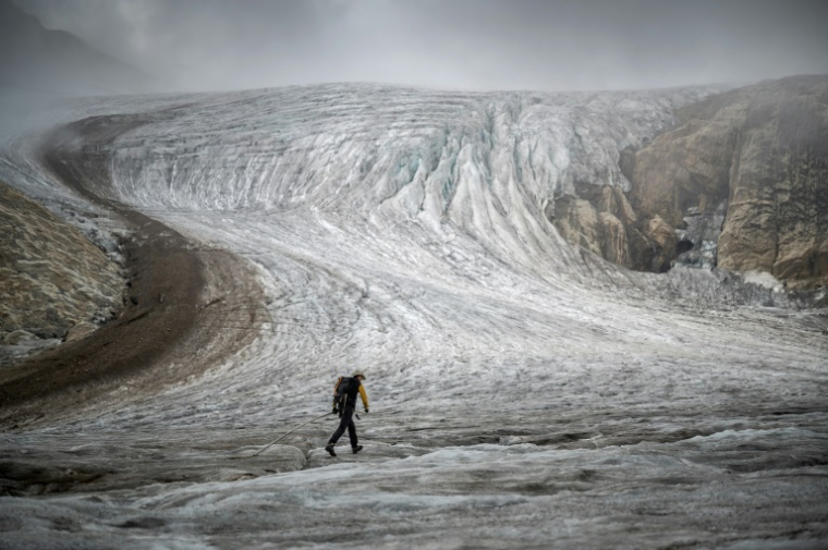 Matthias Huss, directeur de la Surveillance des Glaciers Suisses (GLAMOS), sur le glacier de Gries pour effectuer des relevés avec des équipements de mesure, le 2 septembre 2022 en Suisse ( AFP / Fabrice COFFRINI )