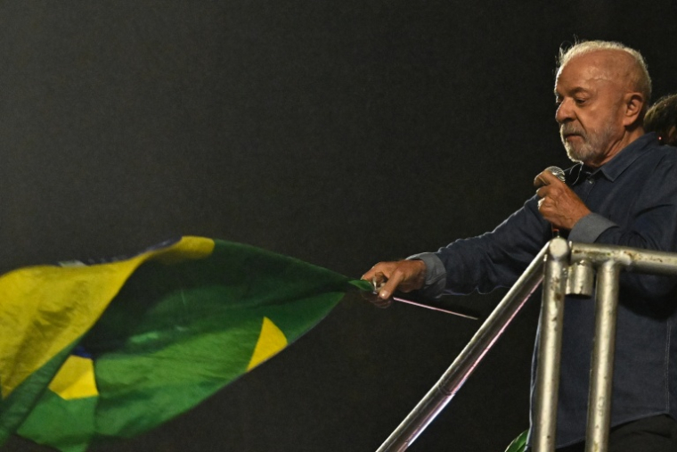 Le président de gauche Lula brandit un drapeau lors d'un discours de victoire au second tour de la présidentielle devant ses partisans à Sao Paulo, dans le sud-est du Brésil, le 25 octobre 2026 ( AFP / Juan BARRETO )