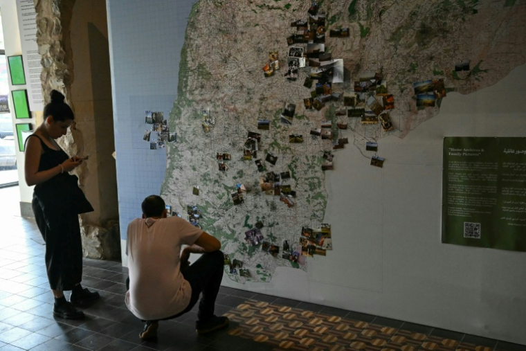 Des visiteurs de l'exposition "Hkeeli ya Jnoub" (Dis-moi, Ô Sud), qui vise à préserver la mémoire des villages détruits par Israël dans le sud du Liban, le 17 juillet 2026 à Beyrouth ( AFP / JOSEPH EID )