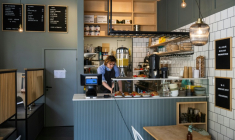 Kajetan Grzelczak derrière son comptoir  au café Andon à Stockholm, entièrement dirigé par l'IA, le 27 avril 2026 ( AFP / Jonathan NACKSTRAND )